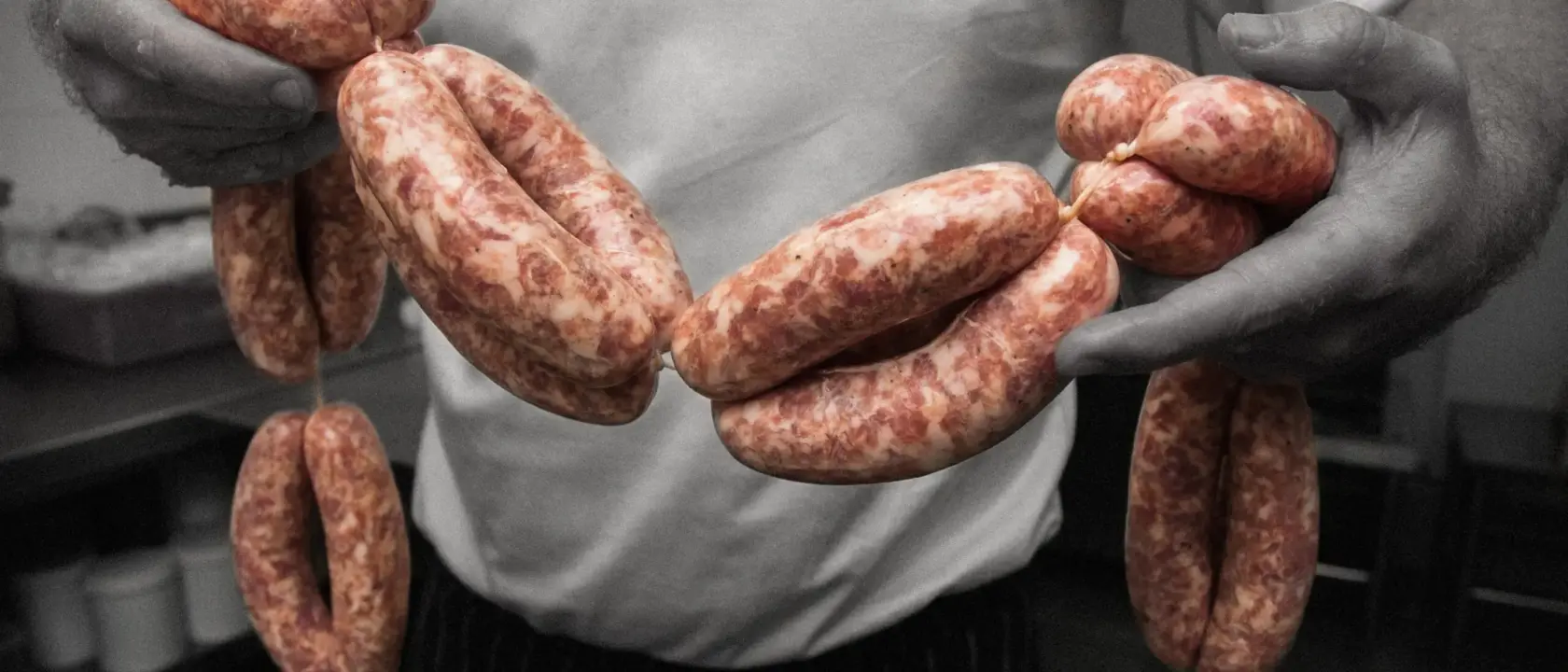image shows joe sloanes with string of butcher sausages